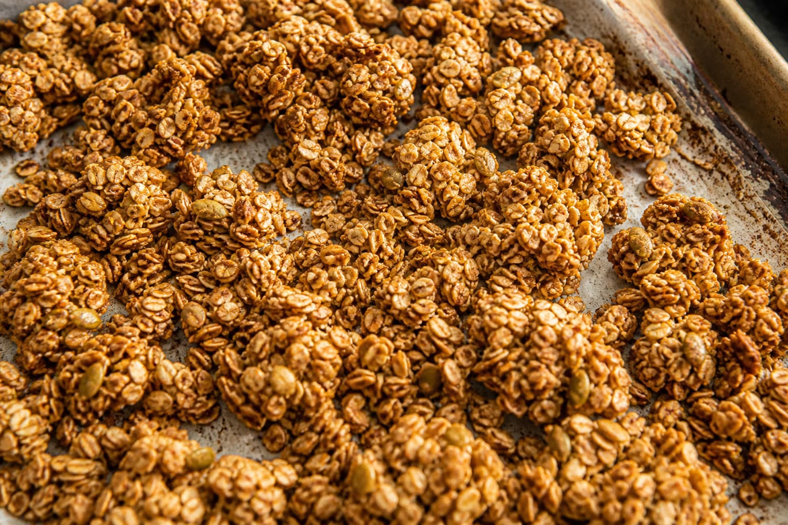 Clustered gluten-free sourdough discard granola on a sheet pan